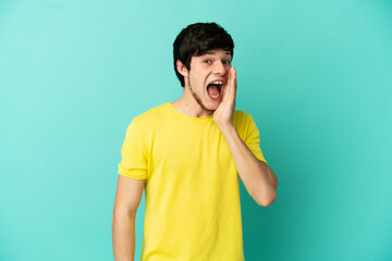 Young Russian man isolated on blue background with surprise and shocked facial expression