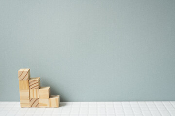 Wood block stairs on white tile table. gray wall background. Business development, growth concept
