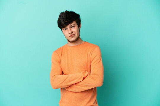 Young Russian man isolated on blue background feeling upset