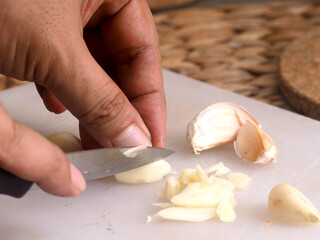 hand with kitchen knife, cutting onion in white cutting board