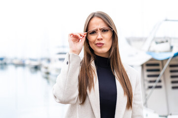 Young pretty woman at outdoors With glasses and frustrated expression