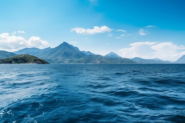 A large lake surrounded by mountains reflects the sky and clouds