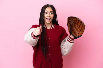 Teenager player with baseball glove isolated on pink background surprised and pointing front - obrazy, fototapety, plakaty