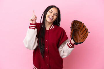 Teenager player with baseball glove isolated on pink background showing and lifting a finger in...