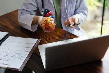 Female cardiologist doctor showing heart anatomy model and counseling to patient on video call