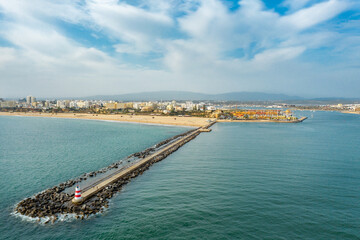 Obraz premium Aerial view of famous Portuguese city Portimao. View of beautiful La Rocha Beach at left, Portimao Marina in right side. European travel destination. Panoramic view of all region.