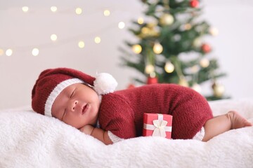 Obraz na płótnie Canvas Cute New born baby sleeping in santa claus hat and gift box.