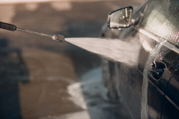 Fototapeta na wymiar Worker washing car at self-service car wash
