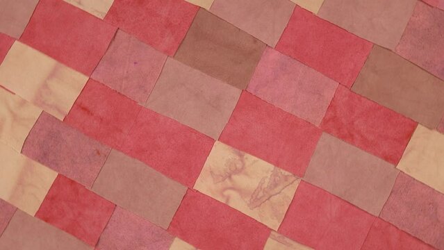 Handmade background in patchwork style with cotton fabric elements in red tones