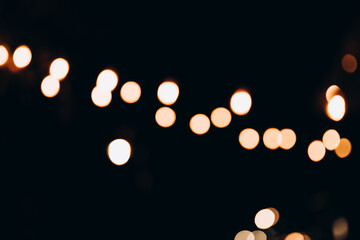 Decorative string lights at night time, Defocused Background, night city backdrop, party time with Yellow bokeh balls.