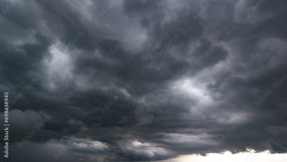 Wall mural the dark sky with heavy clouds converging and a violent storm before the rain.bad or night weather s