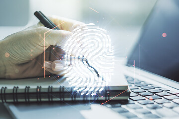 Double exposure of abstract creative fingerprint hologram with hand writing in notepad on background with laptop, protection of personal information concept - Powered by Adobe