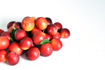 Harvest in the form of a slide of ripe plums on a white background.