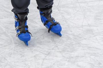 Modern skates with triple fastening on the legs of a teenager on the ice