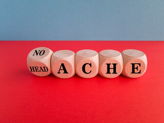 Turned a wooden cube and changes the word headache to no ache. Beautiful red table, blue background. Headache treatment and prevention.