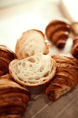 Close up shot plate of golden brown, flaky, buttery crust, warm and delicious croissants and one cut in half. Concept of food, bakery, cuisine, desserts, cooking recipes, traditions.