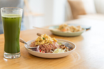 Asian Girl  eating Thai food in kitchen counter Home delivery food feeling happy 