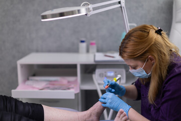 The beautician meticulously and accurately performs pedicures on the client.