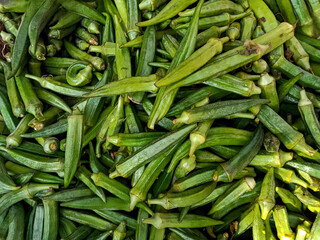 Lady fingers, also known as Okra, pile or heap in the background. Lady Fingers in the local wholesale market, Sabzi Mandi, in Karachi, Pakistan.