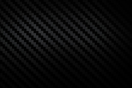 Carbon fiber composite raw material background. Carbon fiber texture. Dark Gray background with lighting.