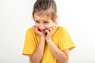 Scared and anxious girl, biting her fingernails on a white background isolated.
