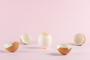 Cracked eggshell with broken Easter eggs against pastel pink background. Easter minimal concept. Creative Happy Easter or spring layout.