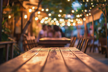 A romantic outdoor dining setting with a wooden table under a canopy of twinkling lights and a blurred couple in the background - obrazy, fototapety, plakaty