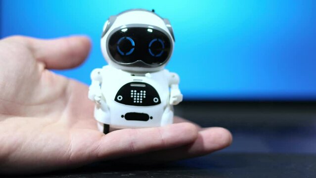 Real small Robot on man's hand. Real Robot on virtual screen online system. Digital Chatbot, Conversation assistant, AI Artificial Intelligence concept. Futuristic future technology. 