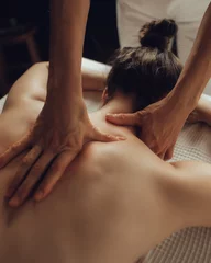 Badkamer foto achterwand Massagesalon Hands of female chiropractor massaging shoulders of young woman lying on massage table. Concept of physical therapy treatment ,neck pressure point