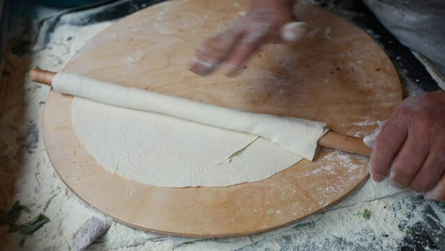 Woman rolling a dough, cooking process