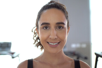 Footage portrait of beautiful - sportive Hispanic woman relaxing and taking a deep breathing after finished exercise in a gym. Good looking and beautiful sport woman smiles to camera.