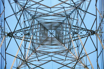 looking up inside a electricity pylon with a blue sky - obrazy, fototapety, plakaty