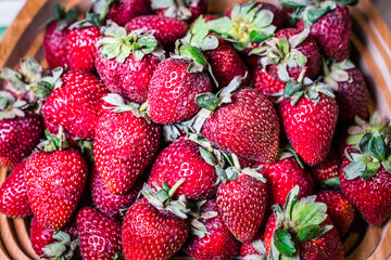 Fresh, fragrant, and delicious organic red strawberries in wooden bowl. Strawberry bowl, top view.