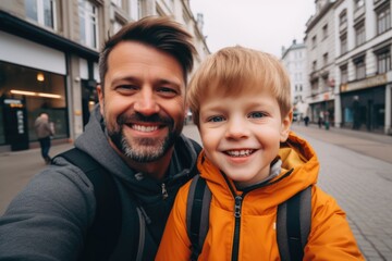 Portrait of a father and little son taking selfie in the city