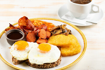 Fried eggs with sausages, nuggets, mushrooms and cup of coffee. Βreakfast concept.