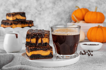 Chocolate brownies with spicy pumpkin cheesecake. Halloween or Thanksgiving dessert. Copy space.
