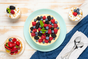 Homemade cake with fresh berries on wooden background.