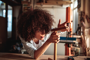 Focused woman crafting in a woodworking studio