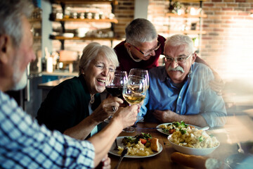 Happy senior people eating together at home