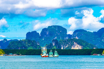 Tropical paradise turquoise water beach limestone rocks fisherboats Krabi Thailand.