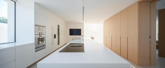 Sleek modern kitchen with clean white lines, integrated appliances, and natural light filtering through slats