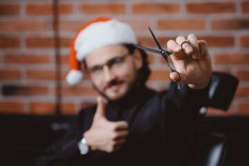 Portrait happy barber man in christmas red hat. Santa hairdresser hold scissors, barbershop xmas...