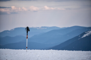 Ski poles against the backdrop of majestic snow-capped mountains.