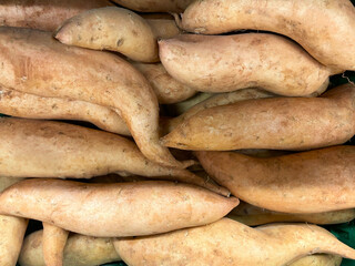 Sweet potato group in detail as a background, fresh vegetables from a market close up, autumn...