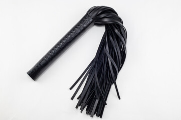 Black flogger on a white background with a stitched handle.