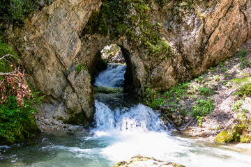 Scenic view of majestic waterfall cascade of Bodentaler Felsentor in Tscheppaschlucht, Loibl Valley, Karawanks, Carinthia, Austria. Unique rock formation. Cascading down cliff face into pool of water