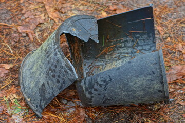 one plastic black dirty broken discarded industrial without a handle empty round bucket lies on the...