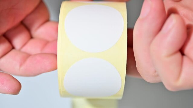 Opening barcode roll labels by hand. Opened thermal barcode roll.	