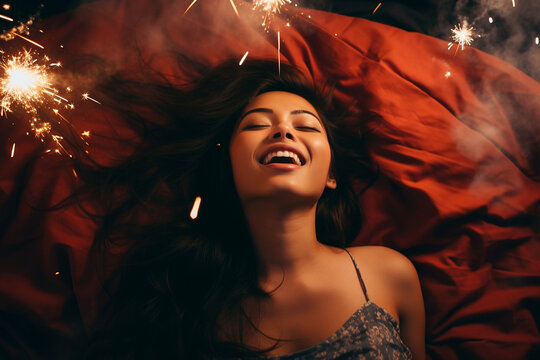 Young multiracial woman having orgasm. Beautiful woman with open mouth and closed eyes enjoying sex lying among fireworks. Sparklers as a symbol of orgasm. Sexual experience, masturbation, cunnilingus