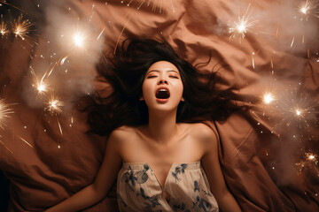 Young Asian woman having orgasm. Beautiful woman with open mouth and closed eyes enjoying sex lying among fireworks. Sparklers as a symbol of orgasm. Sexual experience, masturbation, cunnilingus.